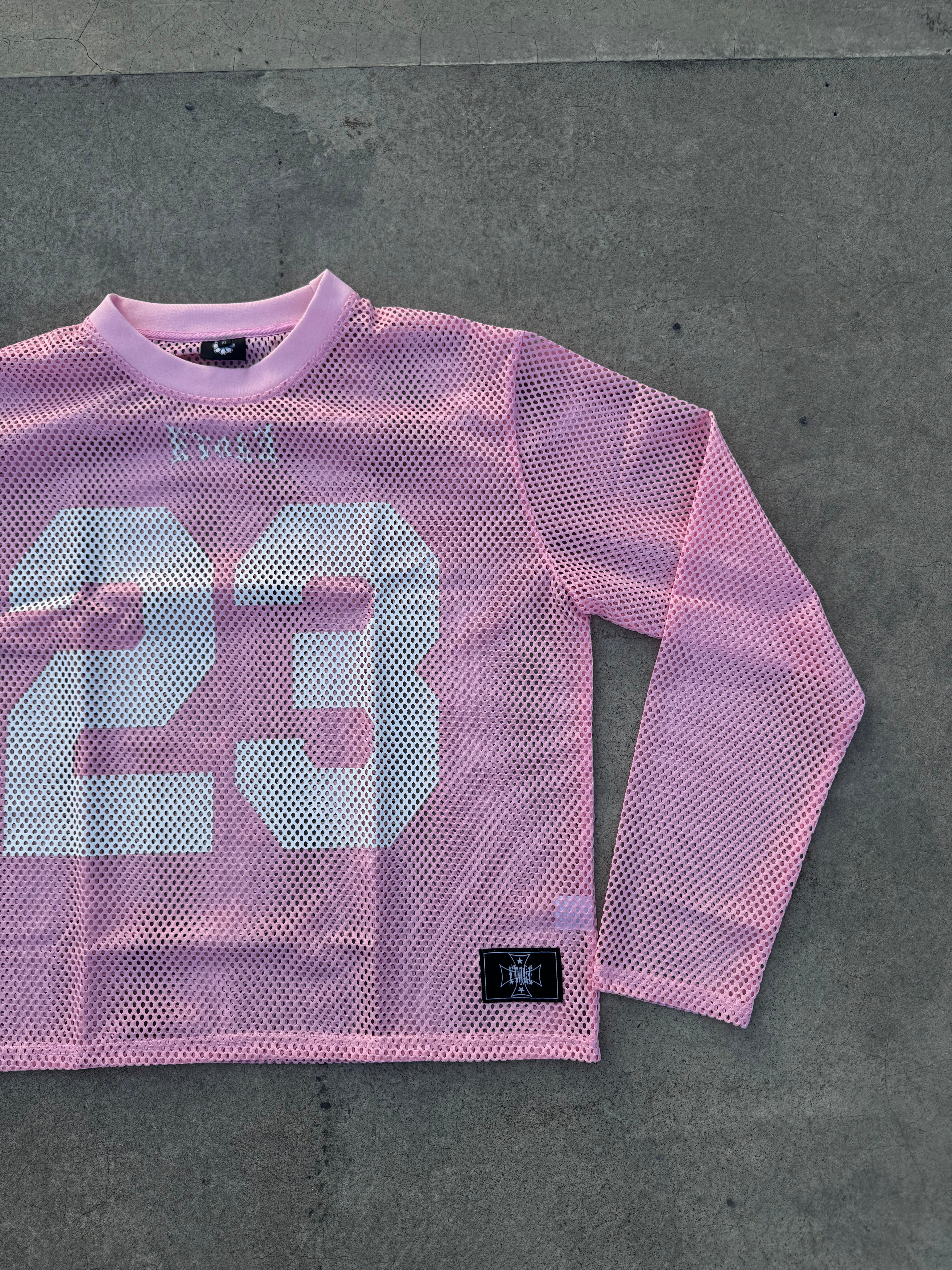 Pink mesh long-sleeve shirt with number 23 on a gray surface