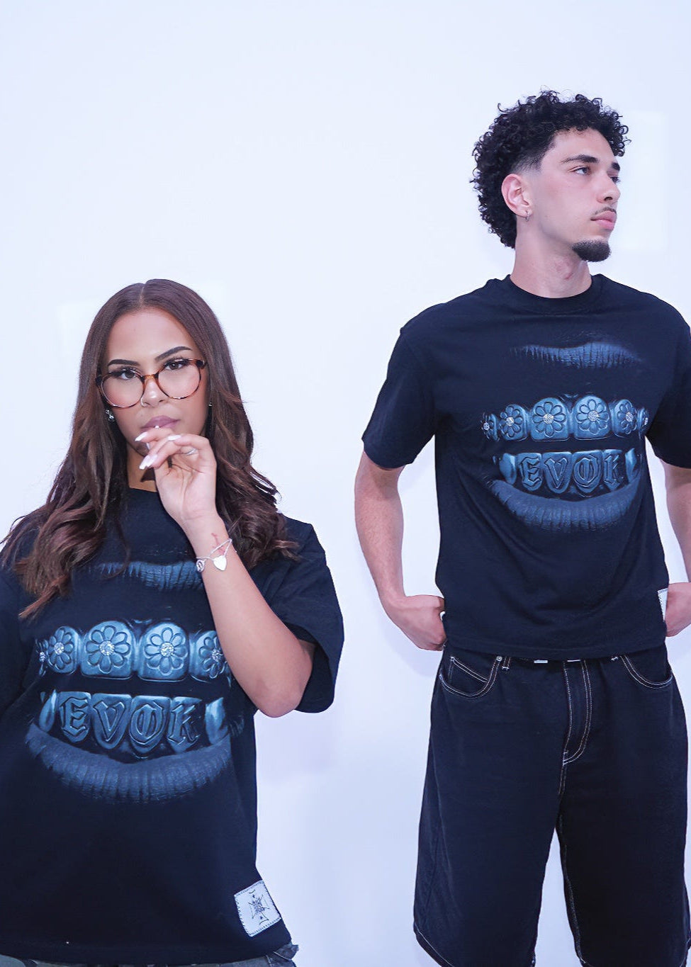 Two people wearing black t-shirts with a blue graphic design on a white background