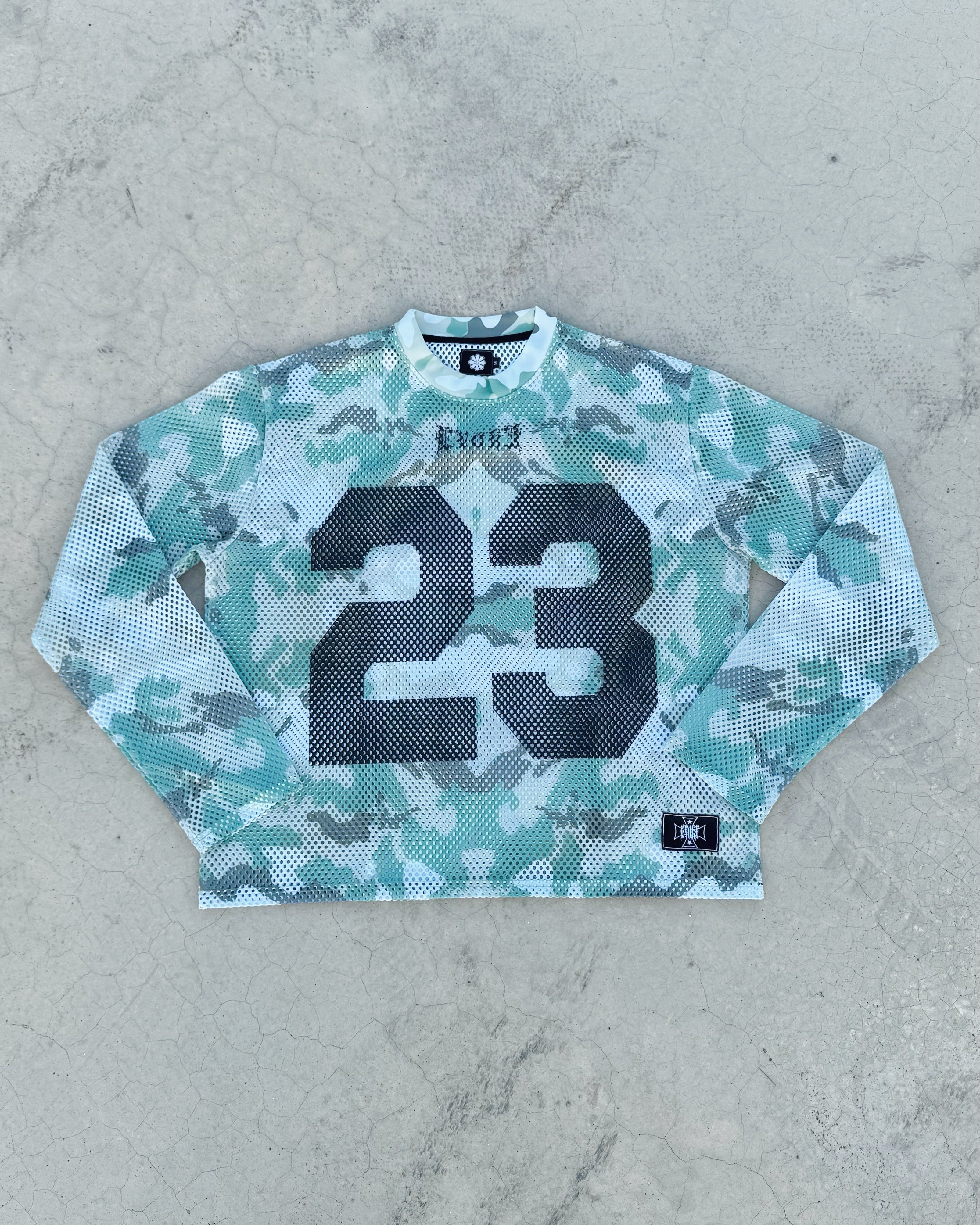 Camouflage-patterned long-sleeve shirt with number 23 on a gray surface